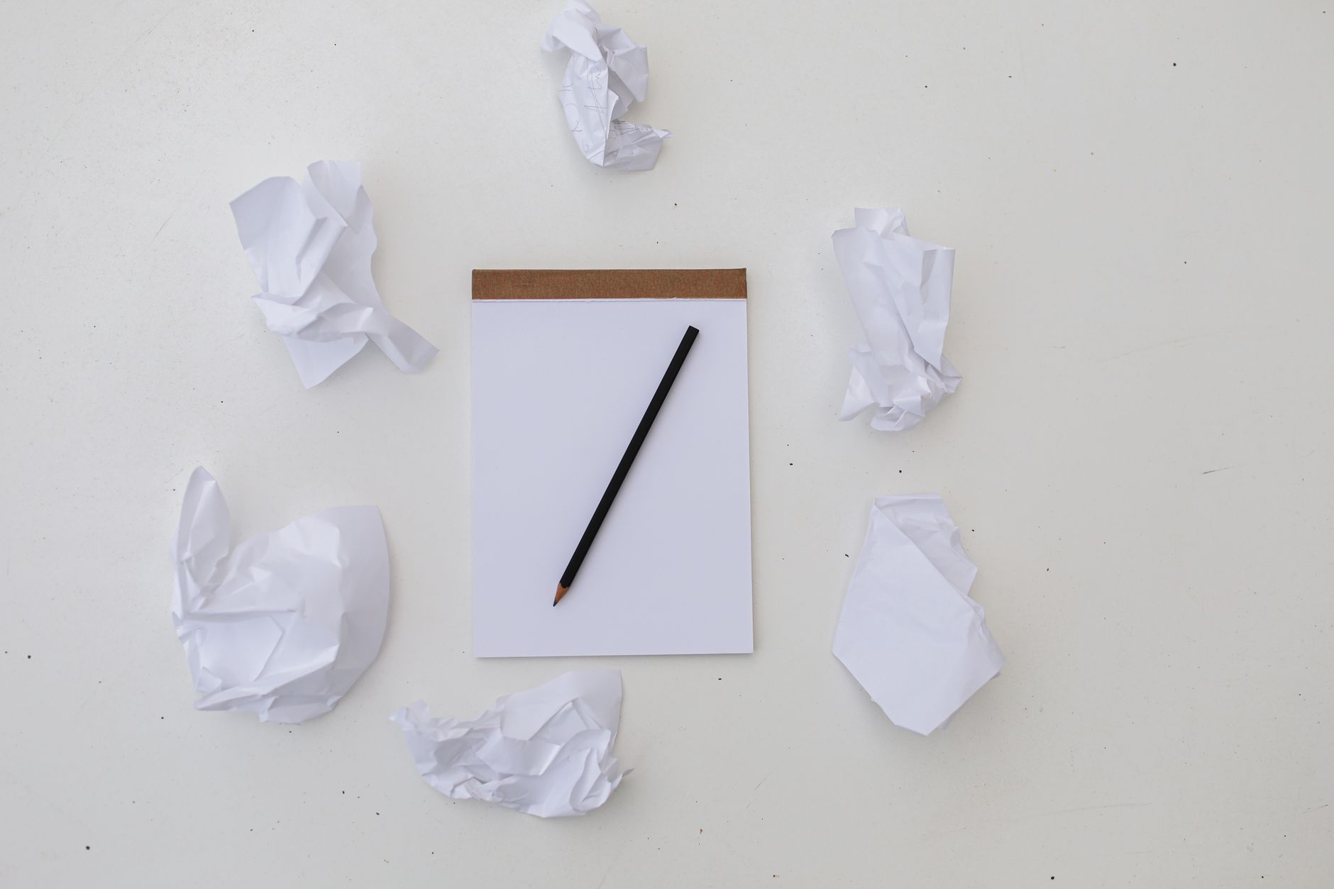a pencil near crumpled paper